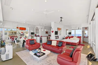 a living room with red furniture and a kitchen at Jewel of La Jolla in San Diego