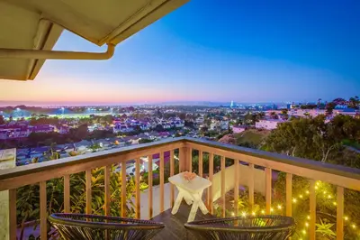 a balcony with chairs and a view of a city at Red Hawk Coastal Estate in San Diego