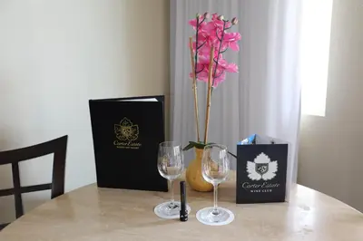 a table with two glasses and a vase with a flower at Carter Estate Winery and Resort in Temecula