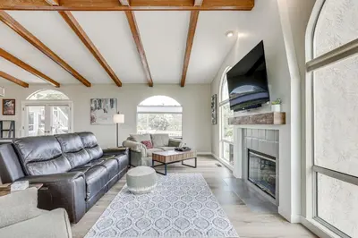 a living room with a leather couch and a fireplace at San Marcos Getaway with Deck and Lake Views! in San Marcos