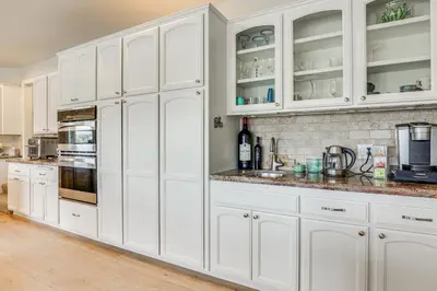 a white kitchen with white cabinets and appliances at San Marcos Getaway with Deck and Lake Views! in San Marcos