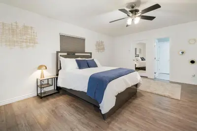 a bedroom with a bed and a ceiling fan at Sunlit Shores beachside Bliss in San Diego