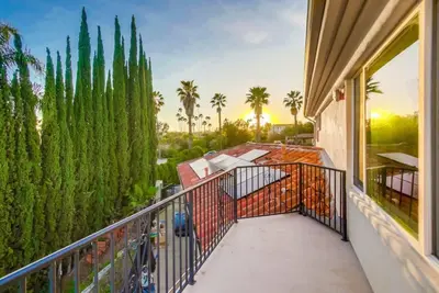 a balcony with a view of a garden and palm trees at Villa Andalusia 6BR 5BA Luxury Jacuzzi Views and Games in Escondido