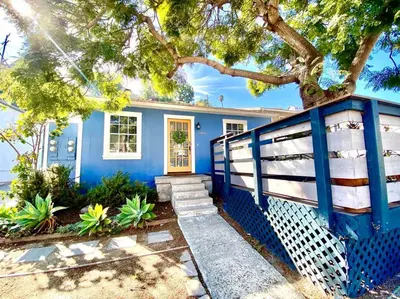 a blue house with a fence and a tree at The Downtown Blue Bungalow Escape in San Diego