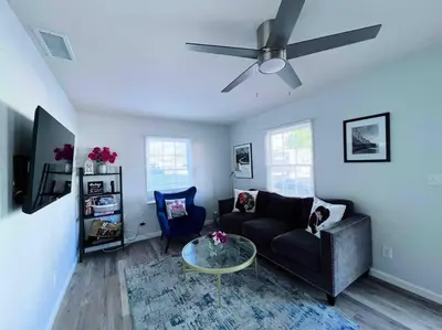 a living room with a couch and a ceiling fan at The Downtown Blue Bungalow Escape in San Diego