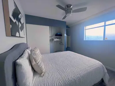 a bedroom with a bed with a ceiling fan at The Downtown Blue Bungalow Escape in San Diego