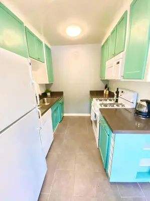 a green kitchen with white appliances and green cabinets at The Downtown Blue Bungalow Escape in San Diego