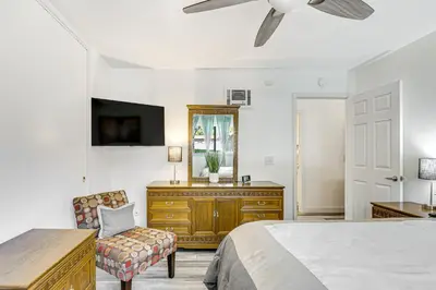 a bedroom with a bed and a dresser and a mirror at Oceanside Condo with Pool and Hot Tub Access! in Oceanside