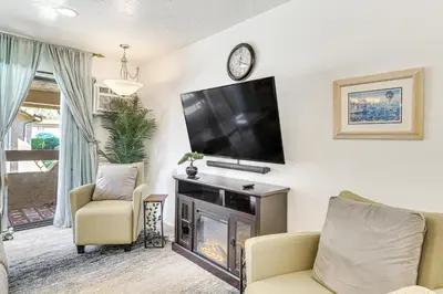 a living room with a fireplace and a flat screen tv at Oceanside Condo with Pool and Hot Tub Access! in Oceanside