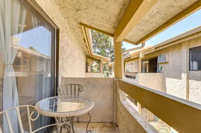 a balcony with a table and chairs and a window at Oceanside Condo with Pool and Hot Tub Access! in Oceanside