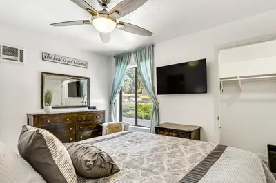 a bedroom with a bed and a tv and a window at Oceanside Condo with Pool and Hot Tub Access! in Oceanside