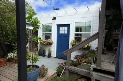 a blue door on a white house with plants at La Jolla Beach Villa Gem in San Diego