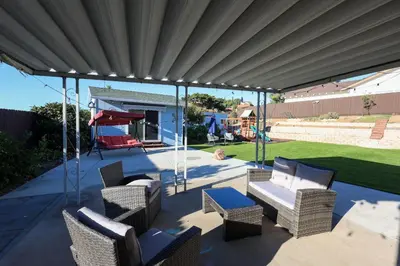 a covered patio with chairs and a swing at Pristine Poway Retreat in Poway