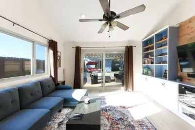 a living room with a blue couch and a ceiling fan at Pristine Poway Retreat in Poway