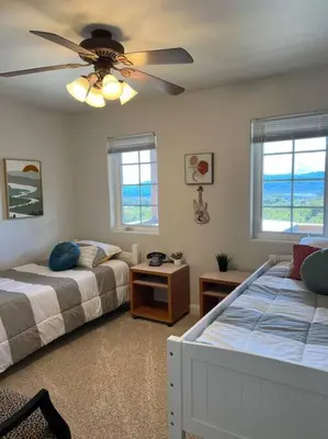 a bedroom with two beds and a ceiling fan at Stylish Country Home with Hot Tub and Amazing Views on 40 Acres in Ranchita