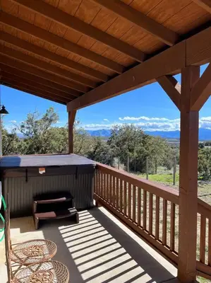 a large wooden deck with a table and chairs on it at Stylish Country Home with Hot Tub and Amazing Views on 40 Acres in Ranchita