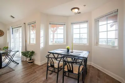 a dining room with a table and some windows at Stylish Country Home with Hot Tub and Amazing Views on 40 Acres in Ranchita