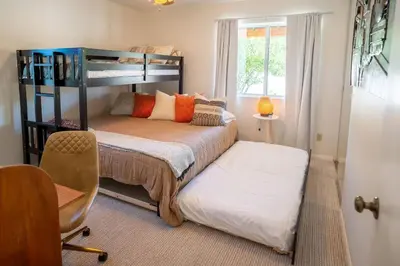 a bedroom with a bunk bed and a chair at Stylish Country Cowboy Home with Hot Tub on 20 Acres in Borrego Springs