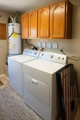 a washer and dryer in a kitchen with wooden cabinets at Stylish Country Cowboy Home with Hot Tub on 20 Acres in Borrego Springs
