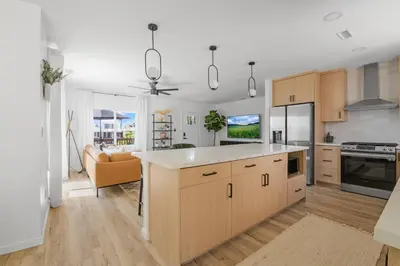 a kitchen with wooden cabinets and a living room at Spacious Mission Hills Home With City Views in San Diego
