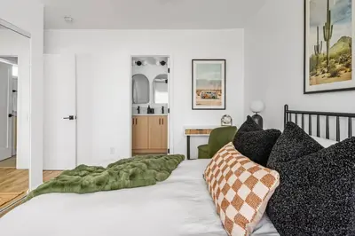 a bedroom with a bed with a green blanket on it at Spacious Mission Hills Home With City Views in San Diego
