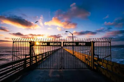 a beach fishing pier with the sunset in the background at Endless Summer Beach Studio - Beach - AC - Shops in San Diego