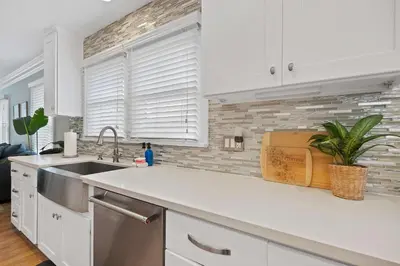 a kitchen with white cabinets and a sink at Endless Summer Cottage - Patio - AC - Beach in San Diego