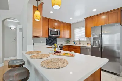 a kitchen with white counter tops and wooden cabinets at Endless Summer Retreat - Beach - AC - Shops in San Diego