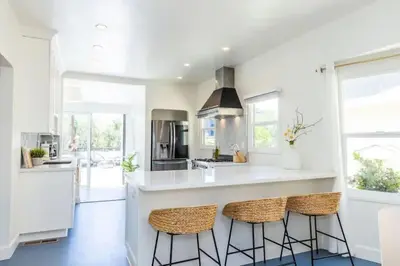 a kitchen with a large white island with bar stools at Little Italy 3BD Home with Huge Patio & Backyard in San Diego