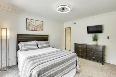 a bedroom with a bed and a dresser with a television at Poway Retreat with Stunning Sunset and Mountain Views! in Poway