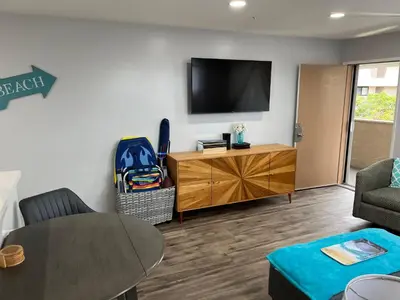 a living room with a table and a tv on a wall at Ocean Breeze 2 bedroom in San Diego