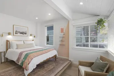 a bedroom with a bed and a couch and windows at 5BD Home with outdoor space in Little Italy in San Diego