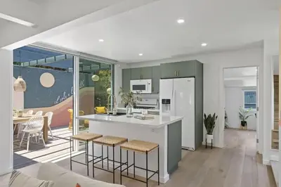 a kitchen with a counter and stools in a room at 5BD Home with outdoor space in Little Italy in San Diego