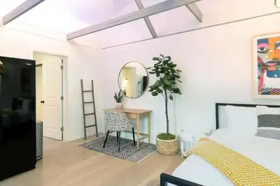 a bedroom with a bed and a table and a mirror at Quaint Studio for 2 in the Heart of Little Italy in San Diego