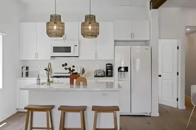 a kitchen with white cabinets and a white refrigerator at 4BD Home in the Heart of Little Italy in San Diego