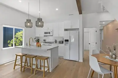 a kitchen with white appliances and a table and chairs at 4BD Home in the Heart of Little Italy in San Diego