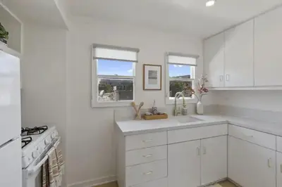 a white kitchen with a sink and a stove at Cozy 1 BR Casita Overflowing with Natural Light in San Diego