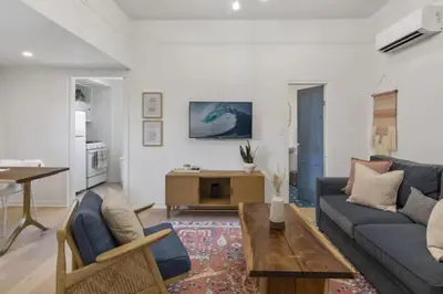 a living room with a blue couch and a table at Cozy 1 BR Casita Overflowing with Natural Light in San Diego