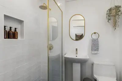 a bathroom with a sink and a toilet and a mirror at Cozy 1 BR Casita Overflowing with Natural Light in San Diego