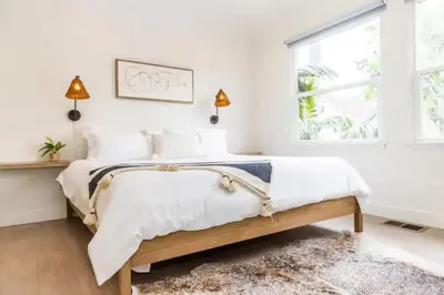 a bedroom with a bed with white sheets and a window at Cheerful 4BD Home in the Heart in San Diego