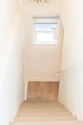 a staircase with a window in a white room at Lovely Studio in the Heart of Little Italy in San Diego