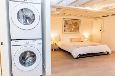 a bedroom with a bed and a washing machine at Lovely Studio in the Heart of Little Italy in San Diego