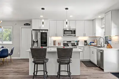 a kitchen with white cabinets and bar stools at The Sky Lounge in La Mesa