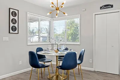 a dining room with a table and blue chairs at The Sky Lounge in La Mesa