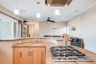 a kitchen with a stove and a counter top at Steps to the boardwalk & beach with AC, WiFi, spacious deck, prime location in San Diego