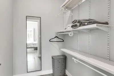 a white room with white shelves and a mirror at 2 Mi to Downtown Escondido Apt with Balconies in Escondido