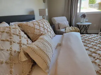 a bed with a blanket and a chair in a room at San Diego Oasis with Hot Tub, Gym, Outdoor Theater, Huge Yard in San Diego