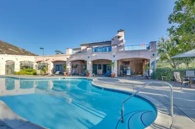 a large swimming pool in front of a house at Sunny San Diego Condo with Pool Access Near Wineries in San Diego