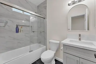 a bathroom with a toilet and a sink and a shower at Urban Retreat Fun Relax Self Check-In Hot Tub Foosball Fire Pit Cornhole in The Woods Trailer Park
