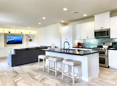 a kitchen with white cabinets and a kitchen island with bar stools at Irvine Luxury 2Bedroom 2Bathroom Portola Springs in East Irvine
